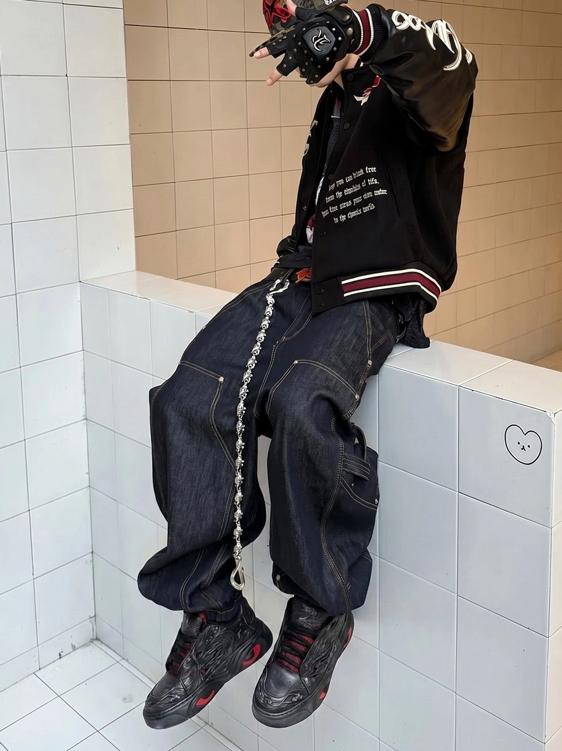Black and red dragon relief chunky sneakers worn with dark denim in a Y2K goth streetwear outfit with coordinated color accents