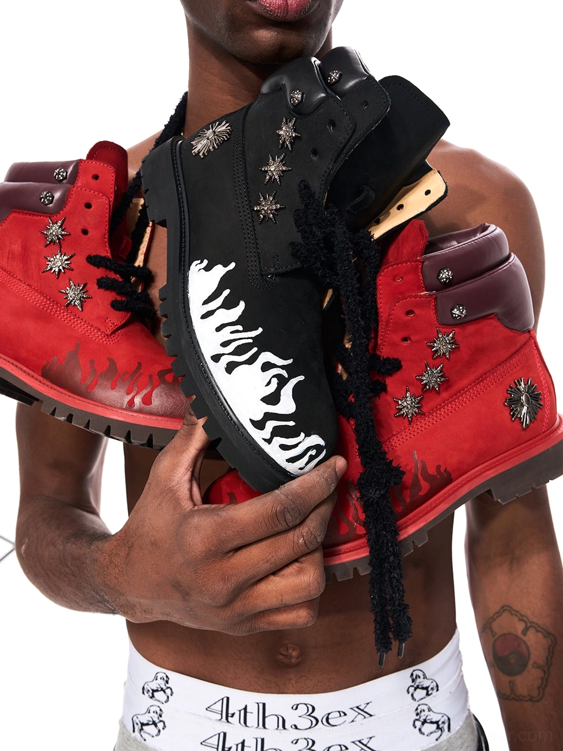 Black and red flame appliqué genuine leather lug sole combat boots displayed together with bold streetwear graphic detailing