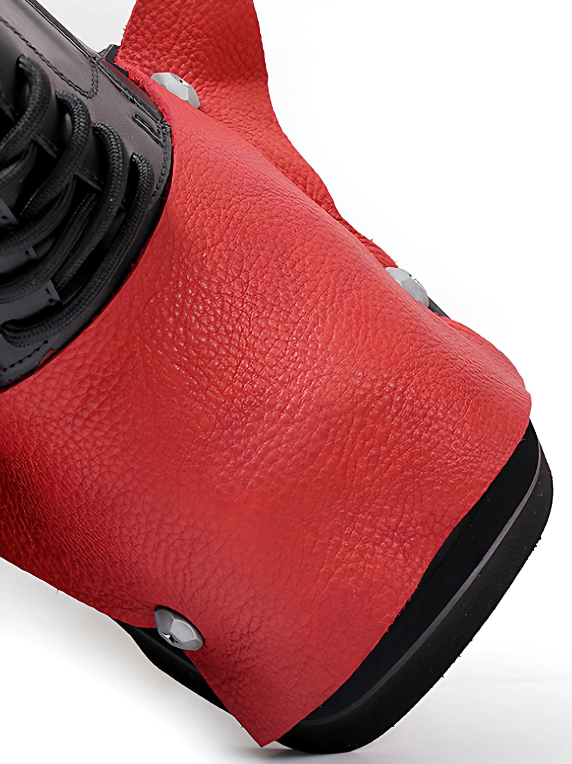 Close-up of textured red peep-toe overlay and silver rivet on black platform derby shoe