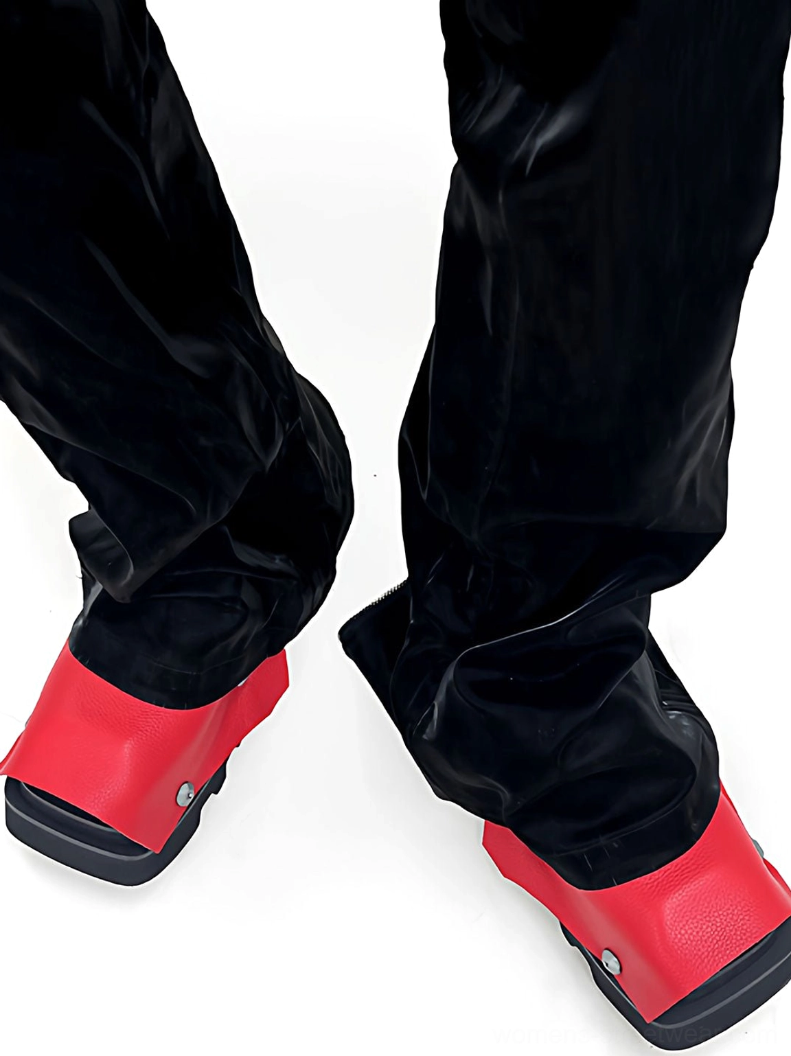 Rear three-quarter view of black and red rivet square-toe platform derby shoes worn with black pants