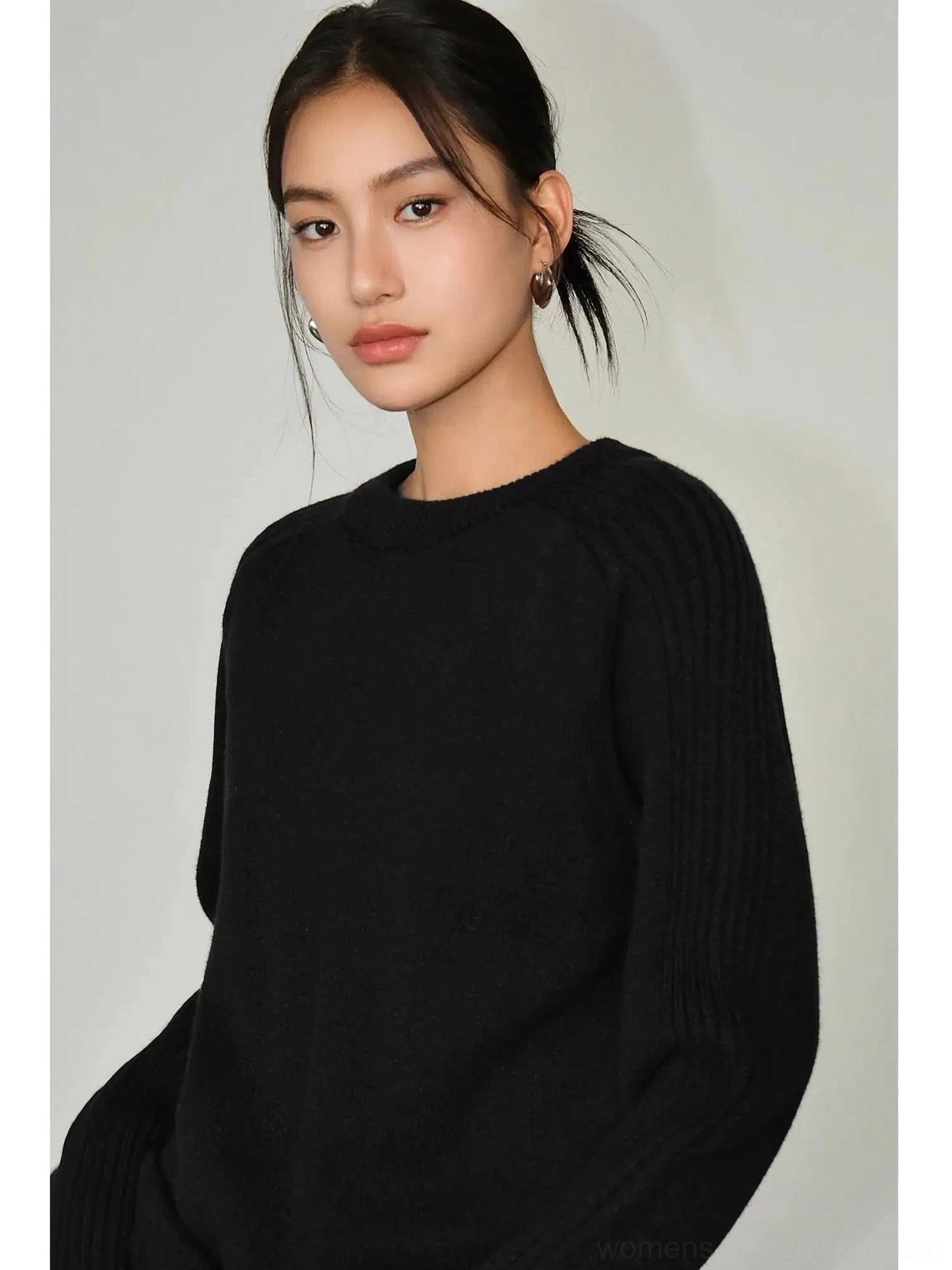Black relaxed crew neck sweater with soft fuzzy knit texture, ribbed sleeves, and loose Korean streetwear fit on a female model