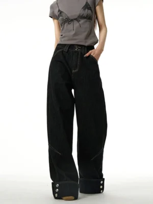 Front view of relaxed black wide-leg streetwear jeans featuring rolled button cuffs, classic waistband, and dark cotton denim