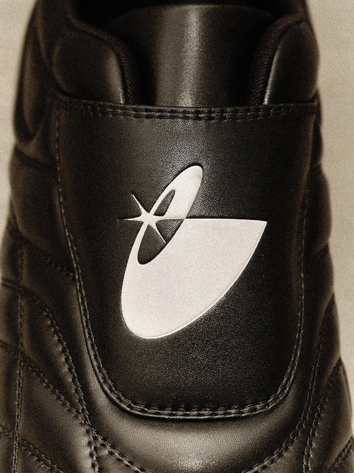 Black retro football sneakers with quilted construction and gum sole styled as contemporary urban streetwear footwear