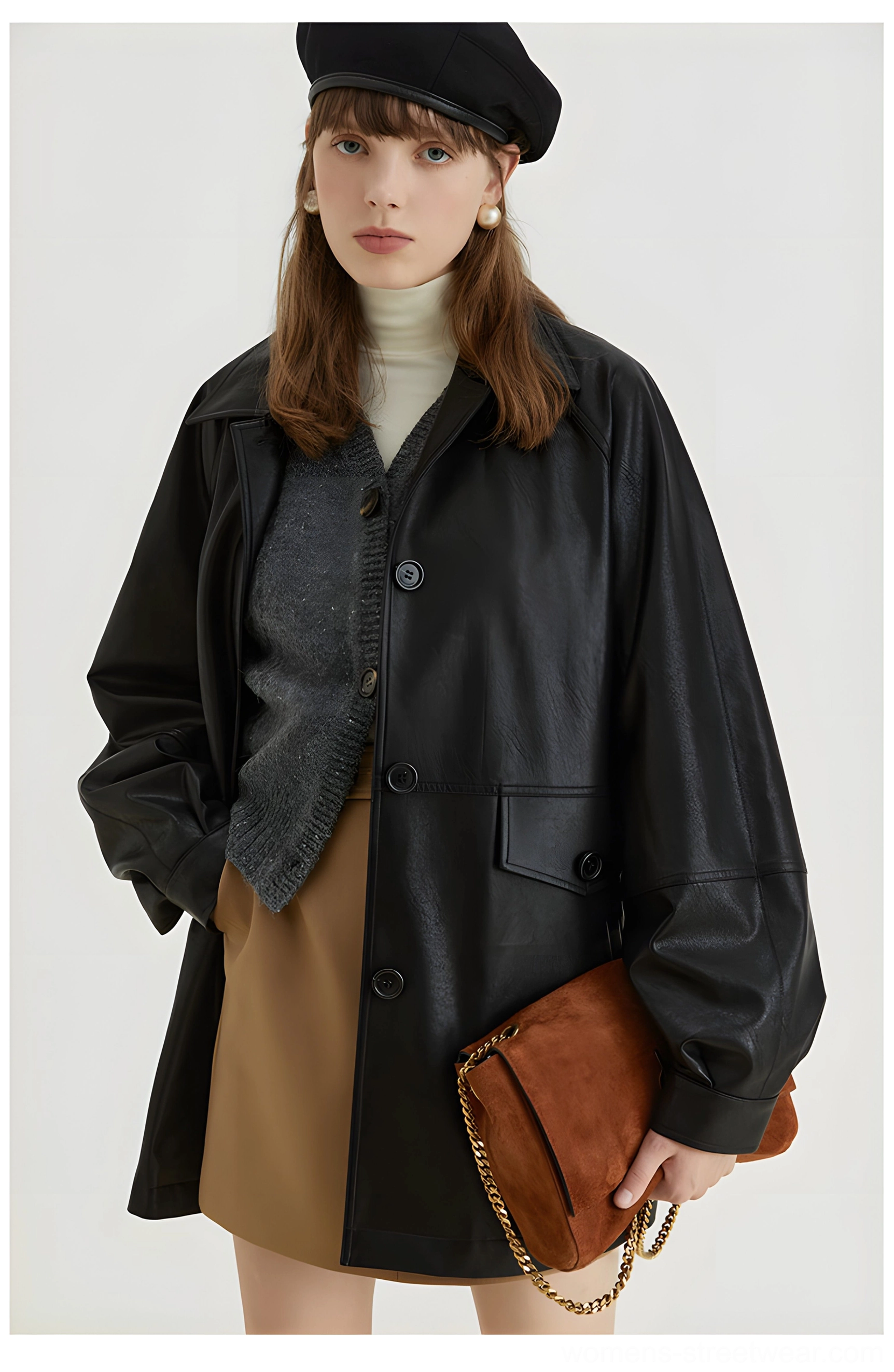 Front full body view of black retro oversized PU leather moto jacket styled with a beret and brown chain shoulder bag