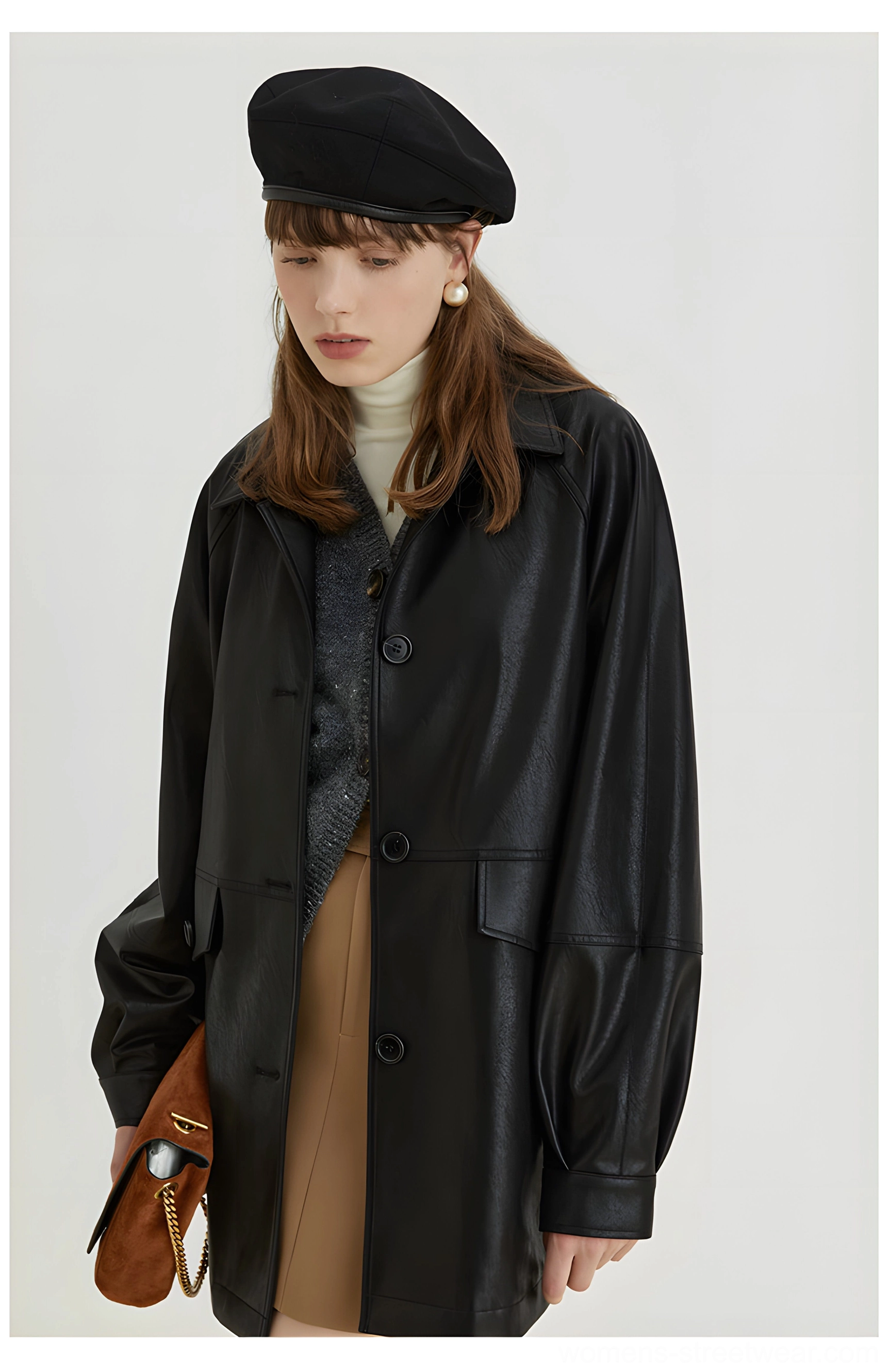 Woman styling a black retro PU leather moto jacket with puff sleeves front flap pockets and a brown chain bag