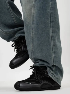 All-black retro running sneakers with matte and glossy paneled upper, round toe, lace-up closure, and washed blue denim styling