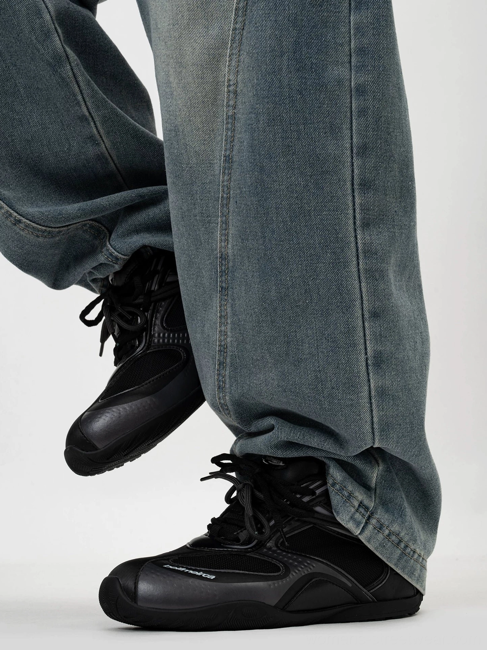 All-black retro running sneakers with matte and glossy paneled upper, round toe, lace-up closure, and washed blue denim styling