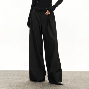 Black retro wide-leg tailored streetwear trousers styled with a slim black knit top, featuring a high-rise waist, front pleats, and structured suiting fabric