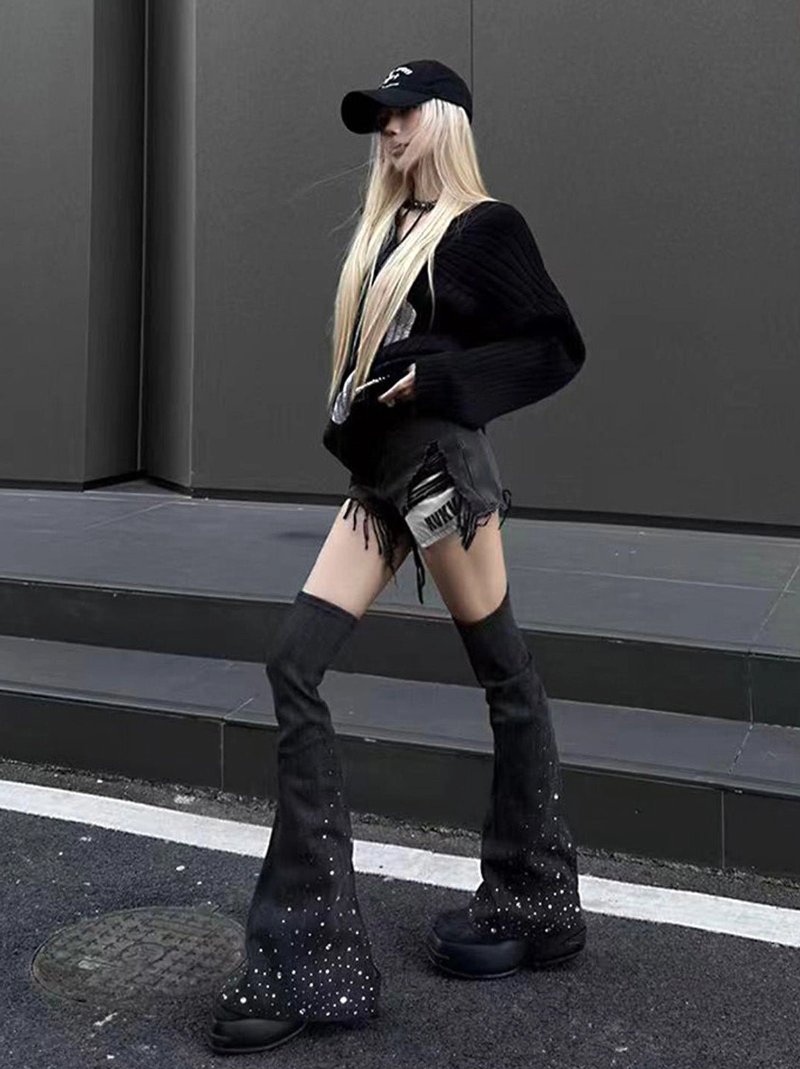 Black rhinestone denim flared over-the-knee platform boots styled for an urban streetwear outfit outdoors