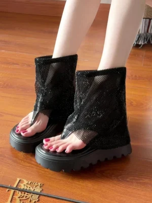Black rhinestone mesh knee-high thong platform sandal boots worn with red pedicure top side view