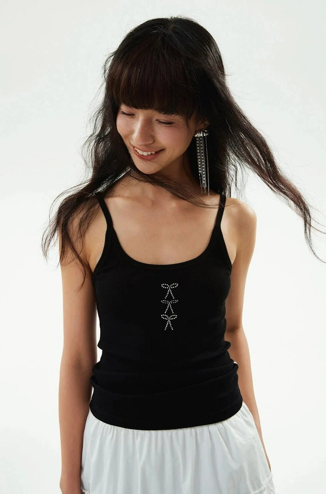 Black ribbed camisole tank top with square neckline styled with a white mini skirt