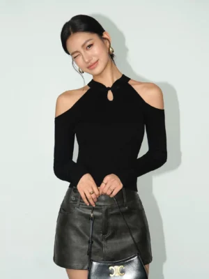 Black ribbed cold-shoulder keyhole knit top with halter-inspired neckline styled with a leather mini skirt and handbag
