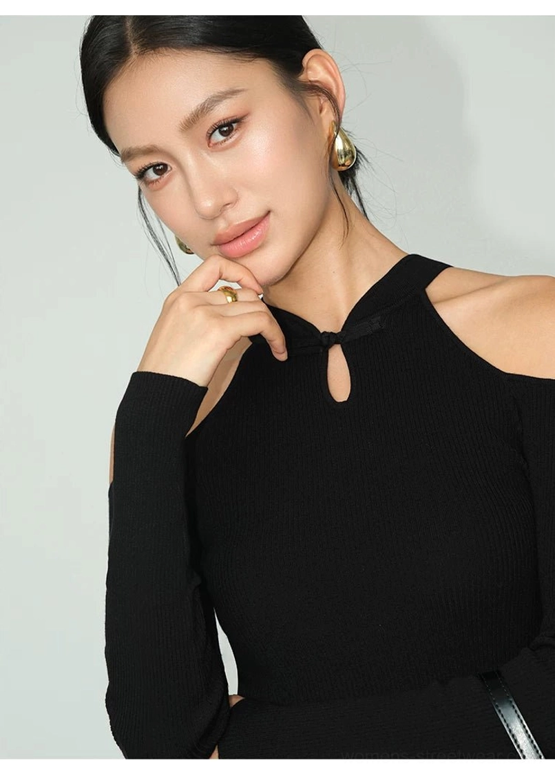 Close-up view of a black ribbed keyhole cold-shoulder knit top showing the neckline and cropped body-hugging fit