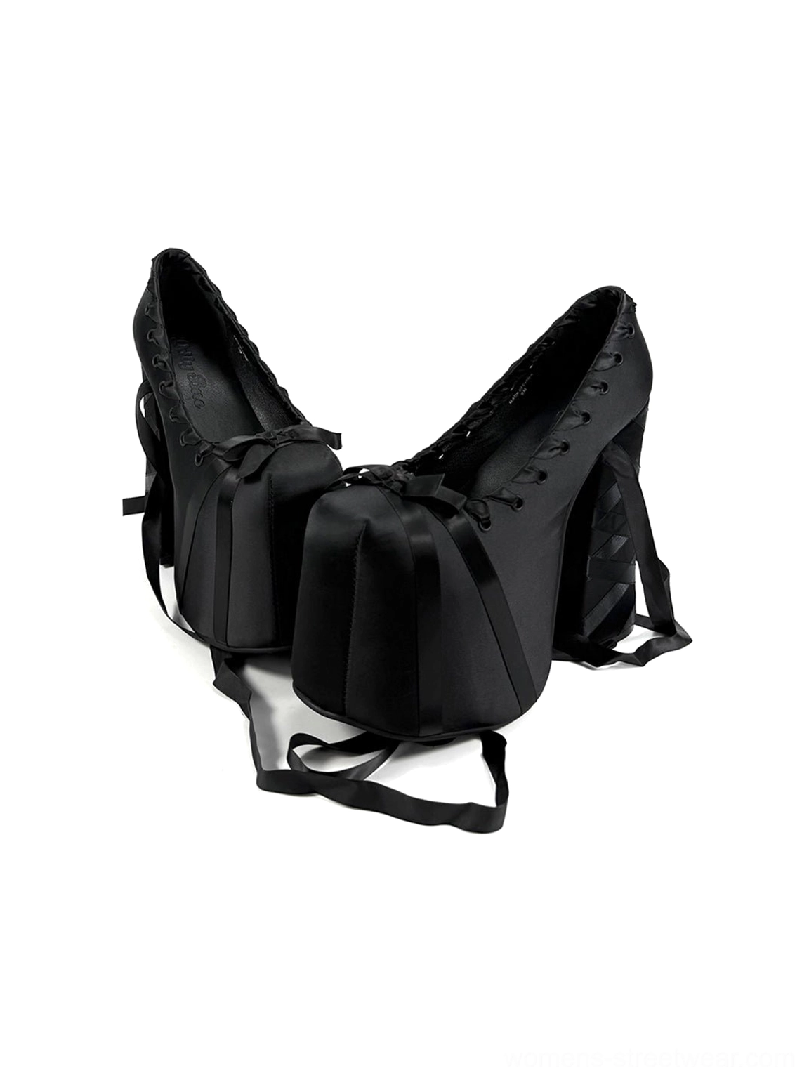 Top-down display of black ribbon lace platform pumps with satin toe bows, lace-up fronts, wrapped block heels, and long ribbons