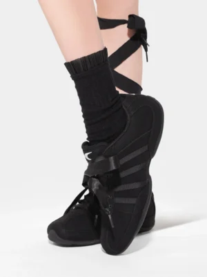 Women's black ribbon lace sneakers styled with ruffled ankle socks and matching leg ribbon accents in a Korean streetwear outfit