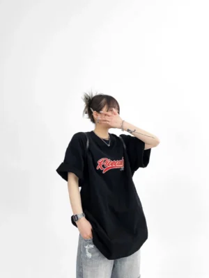 Black Ricecake oversized cotton varsity streetwear T-shirt side view showing relaxed dropped-shoulder silhouette