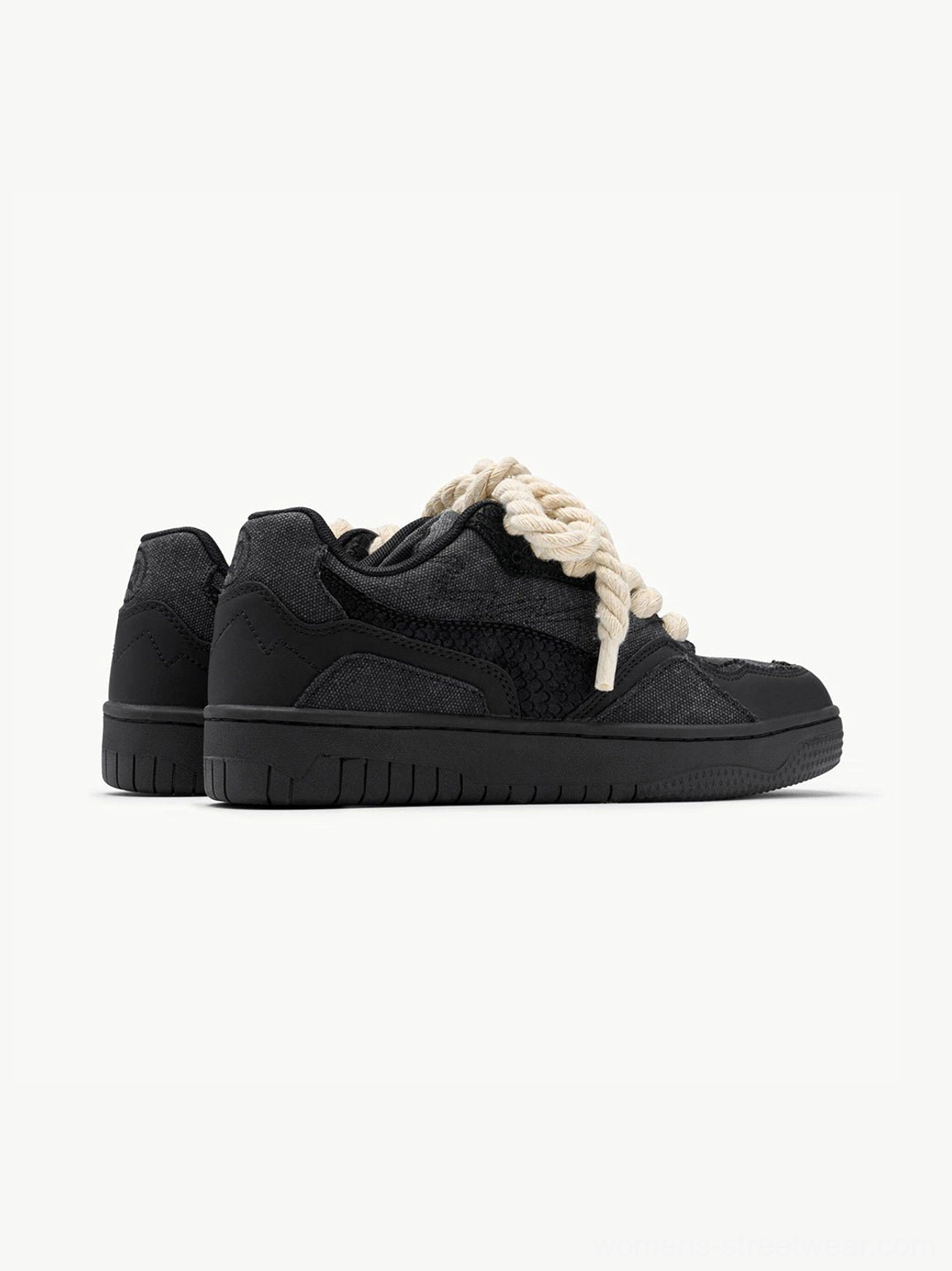Rear side view of black low-top streetwear sneakers with cream rope laces and matte finish
