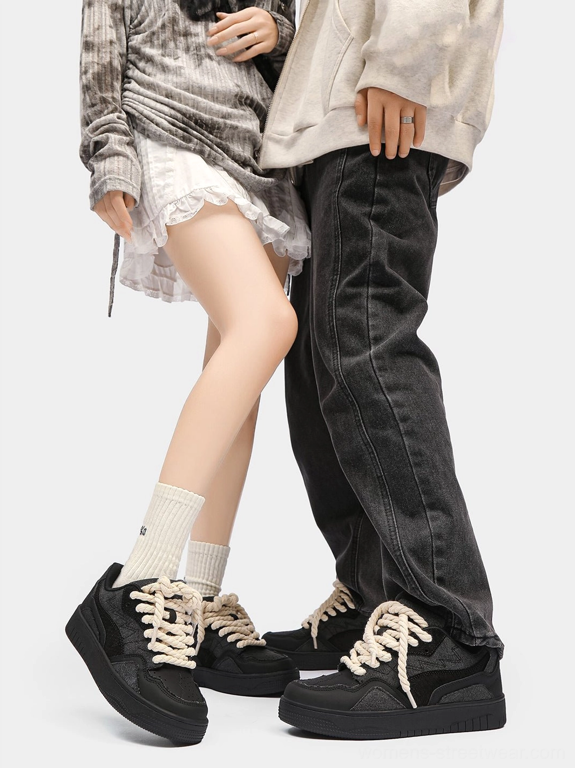 Unisex black rope lace low-top streetwear sneakers worn by two models with skirt and jeans outfits