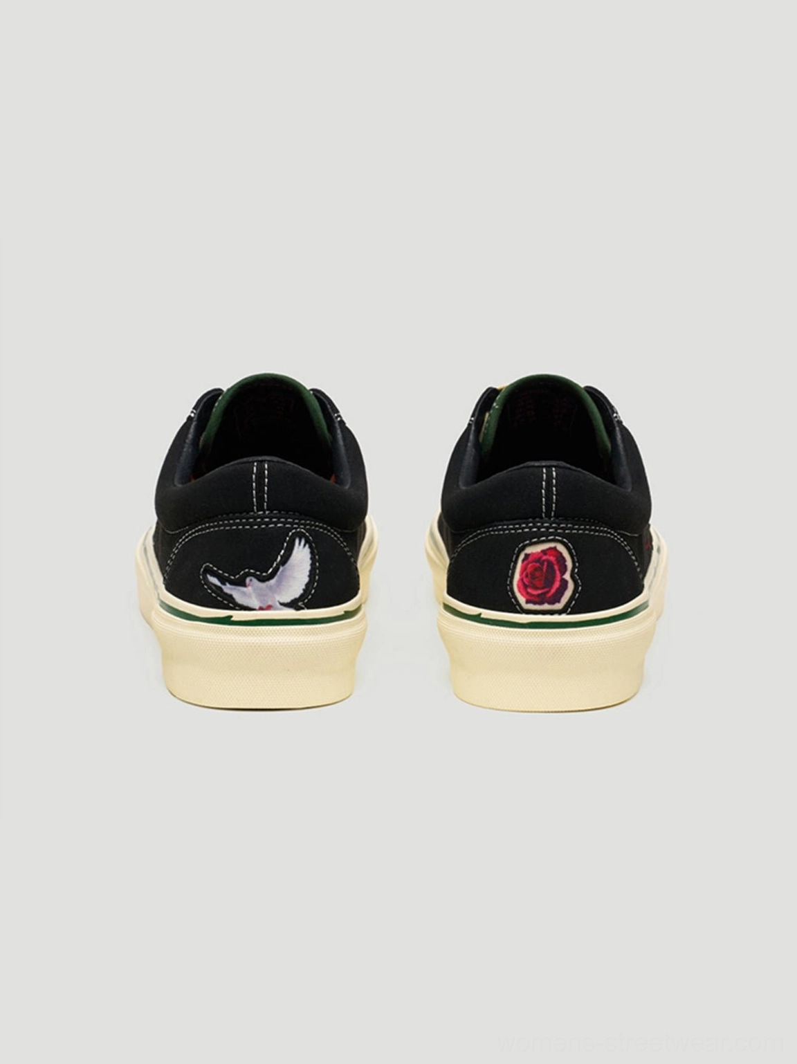 Close-up view of black streetwear skate shoes with floral embroidery, contrast laces, textured upper, and rubber outsole