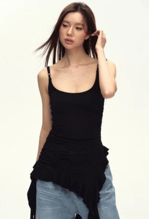 Front close-up of a fitted black ruched cami top with scoop neckline and asymmetric ruffled draped hem