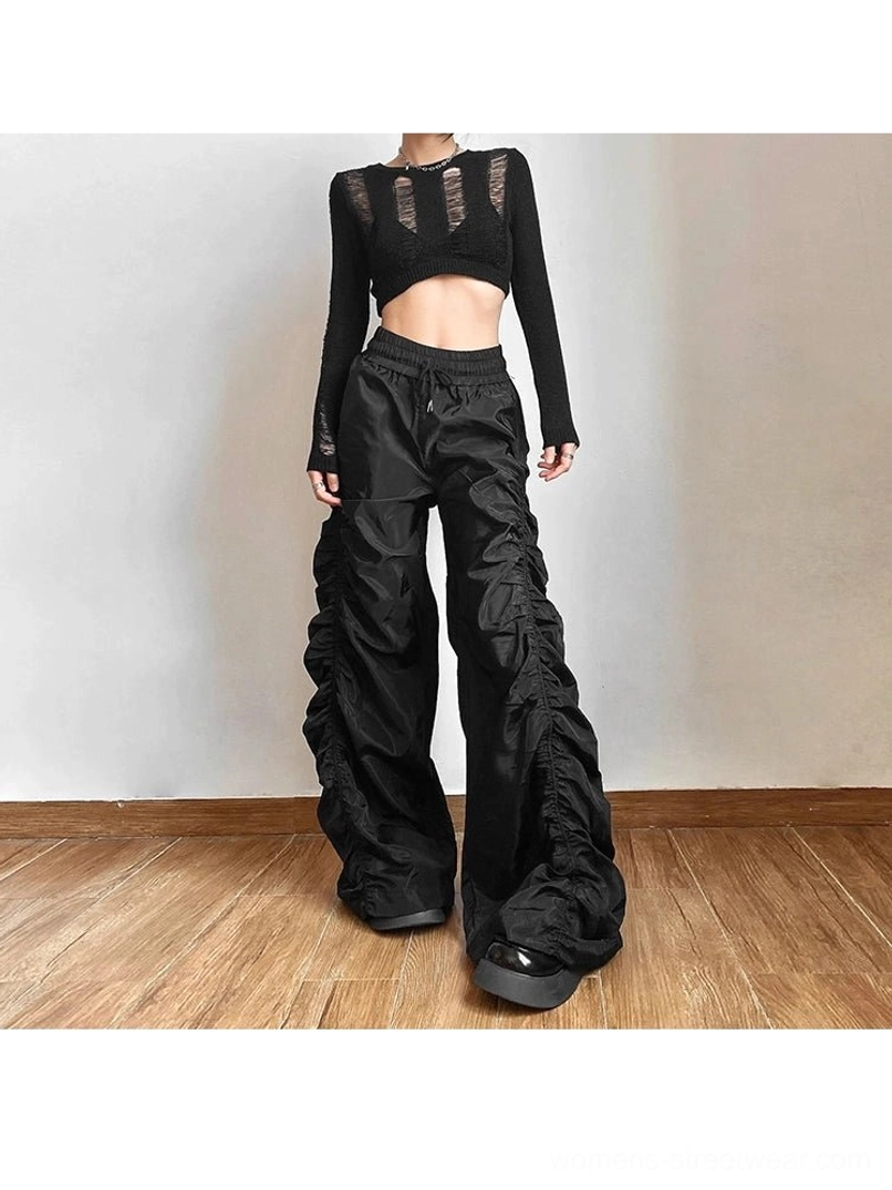 Black ruched high-waist wide-leg streetwear cargo pants styled with a cutout cropped top in a full-body fashion view