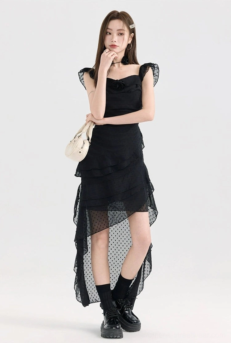 Black ruffle high-low polka dot dress shown in a three-quarter view with fitted waist, square neck, layered skirt, and sheer dotted back hem