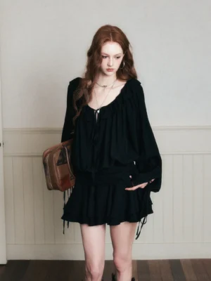Front view of black gothic ruffle poet mini dress set with gathered blouse, tiered skirt and brown leather tote