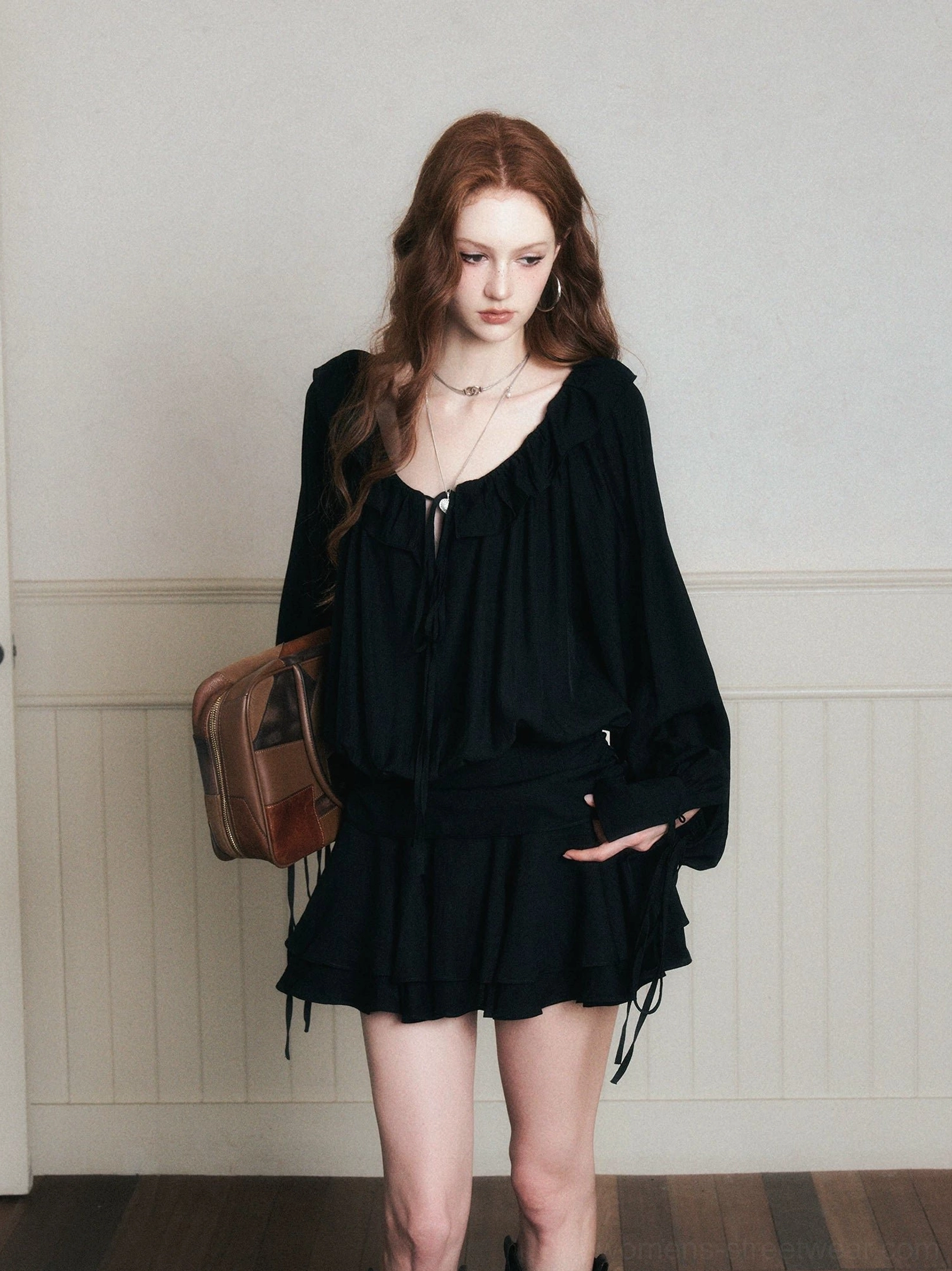 Front view of black gothic ruffle poet mini dress set with gathered blouse, tiered skirt and brown leather tote