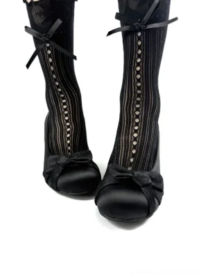 Black satin bow pumps worn with fishnet stockings and bow ankle straps in a modern Korean streetwear styling view