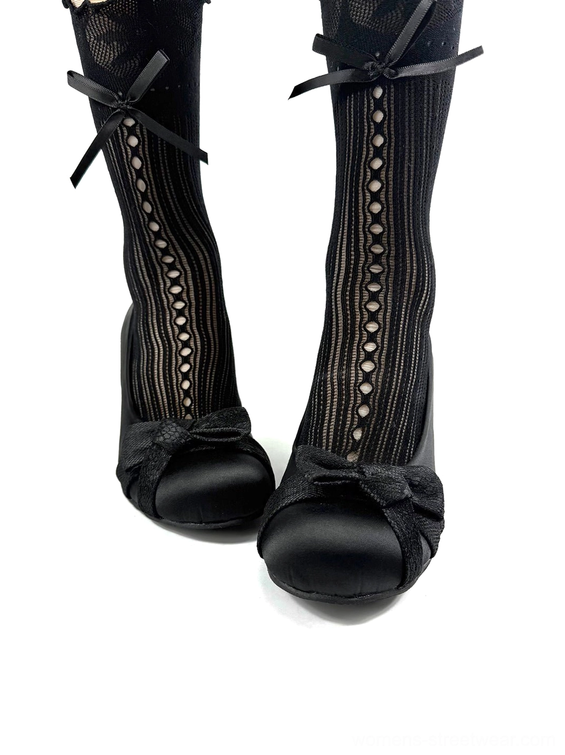 Black satin bow pumps worn with fishnet stockings and bow ankle straps in a modern Korean streetwear styling view