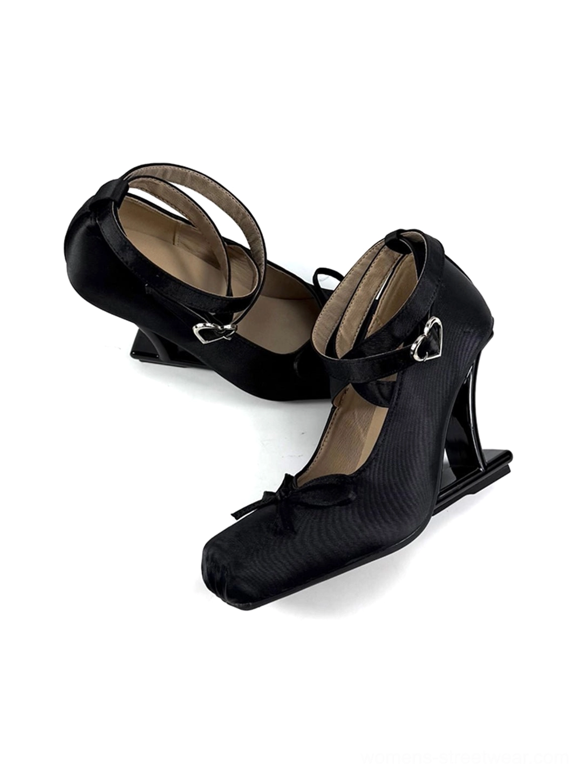 Black satin sculptural heel pumps with heart-shaped ankle buckles, square toes, front bows, and geometric wedge heels