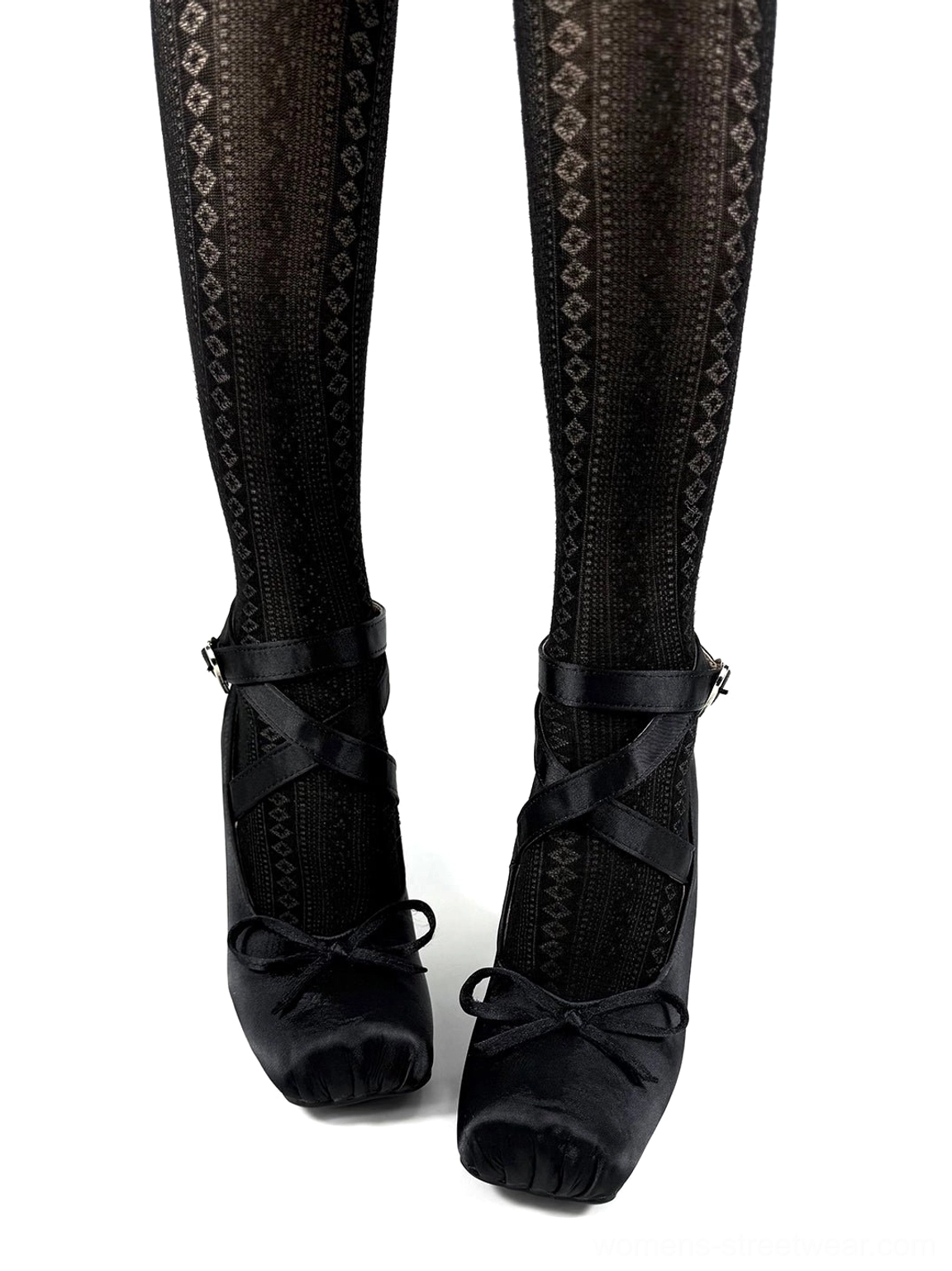 Pair of black satin square toe bow pumps styled with patterned black sheer stockings and sculptural wedge heels
