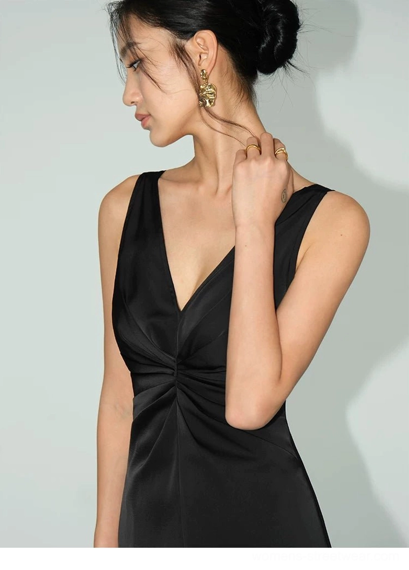 Black satin twist-front dress side close-up showing the deep V-neckline, textured bust gathering, sleeveless cut and smooth satin finish
