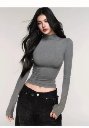 Woman wearing a black slim fit seamless mock neck cropped long sleeve top with vintage washed wide leg jeans in a Korean streetwear studio outfit