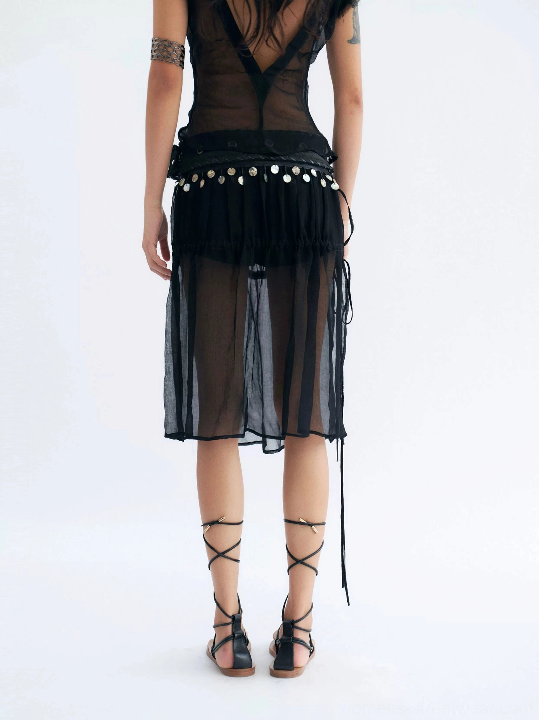 Back view of black sheer midi skirt with metal coin belt trim side slit and built-in shorts