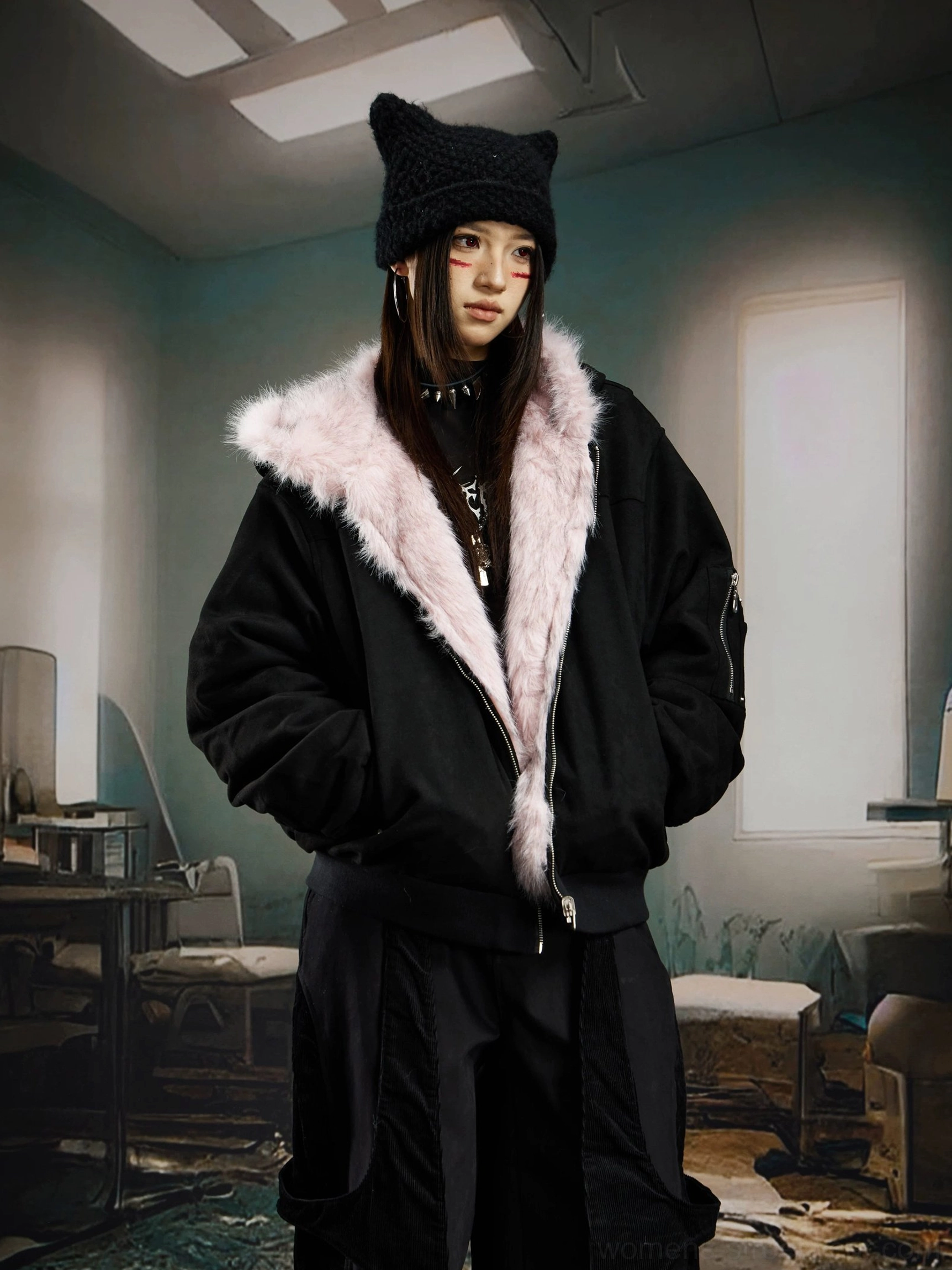 Female model wearing a black shell reversible faux fur hooded bomber jacket with blush pink fur trim