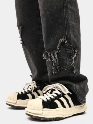 Black and off-white melted shell-toe platform sneakers worn with ripped dark wash denim jeans in a top-down streetwear outfit view