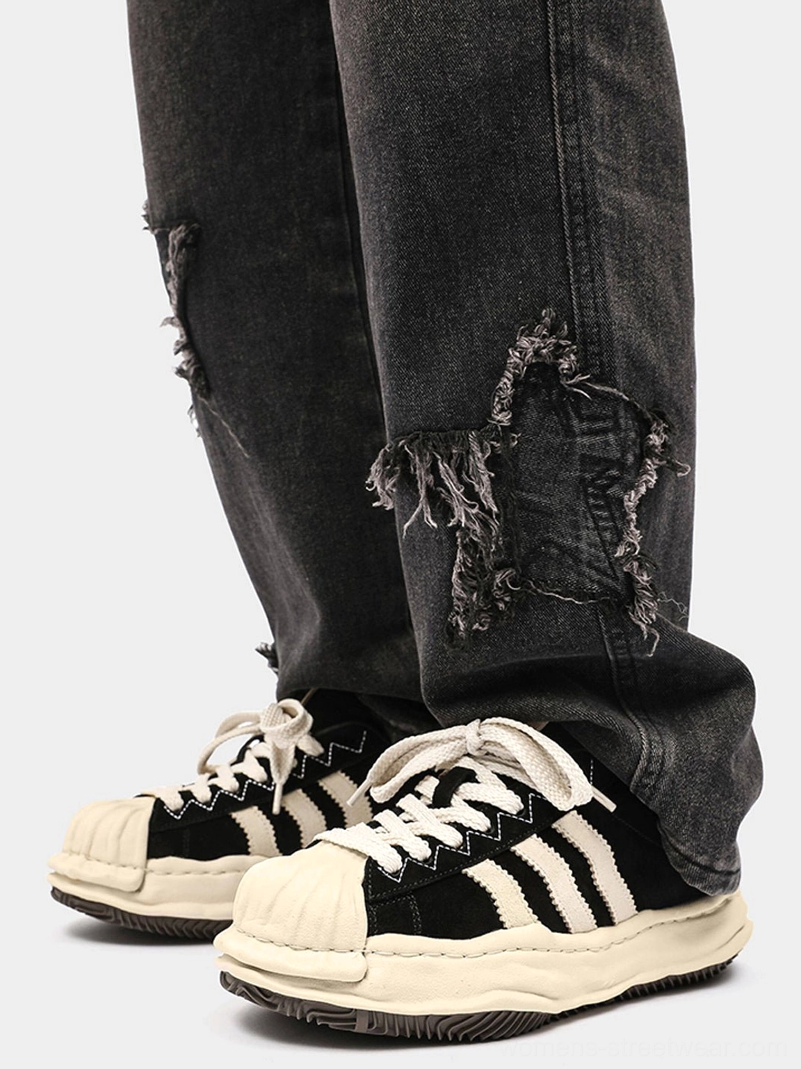 Black and off-white melted shell-toe platform sneakers worn with ripped dark wash denim jeans in a top-down streetwear outfit view