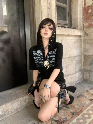 Black short-sleeve hooded graphic T-shirt with silver wing chest print and grommet details styled outdoors