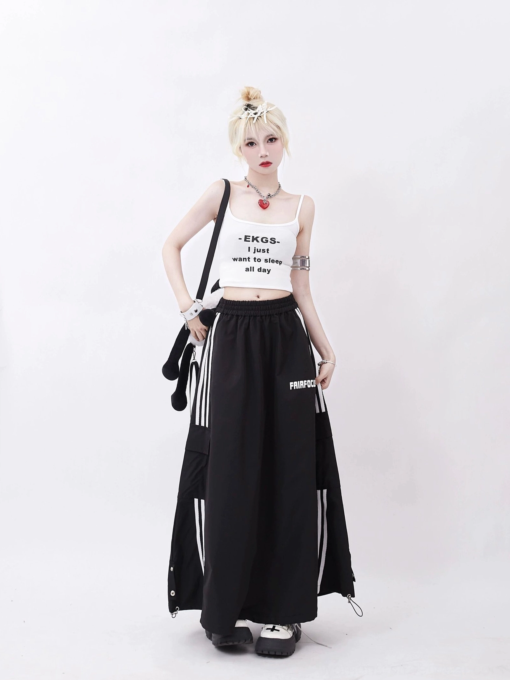 Black side stripe cargo maxi skirt worn in a front three-quarter view with a cropped graphic camisole, showing oversized pockets and adjustable drawstring hem