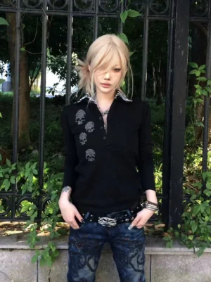 Black skull polo sweatshirt with striped collar worn by a blonde female model with faded printed denim in a streetwear outfit