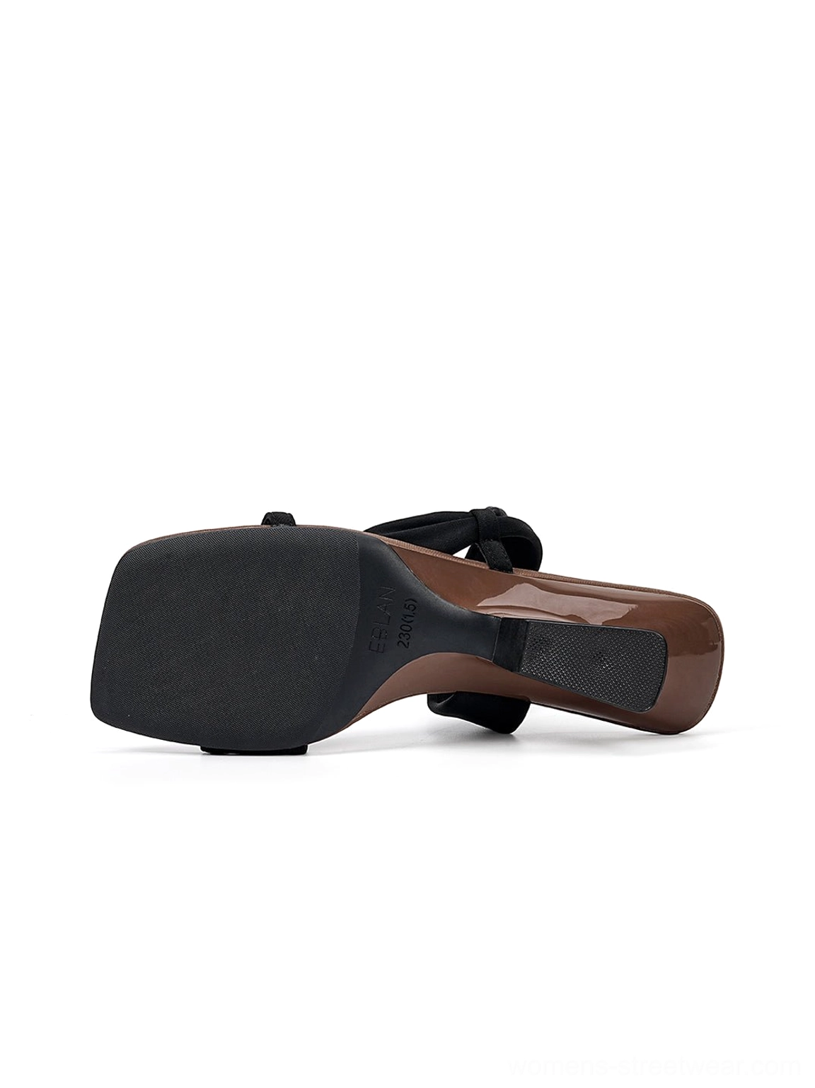 Bottom rear view of black slide sandal with rubber outsole, brown sculptural wedge heel, and asymmetric upper straps