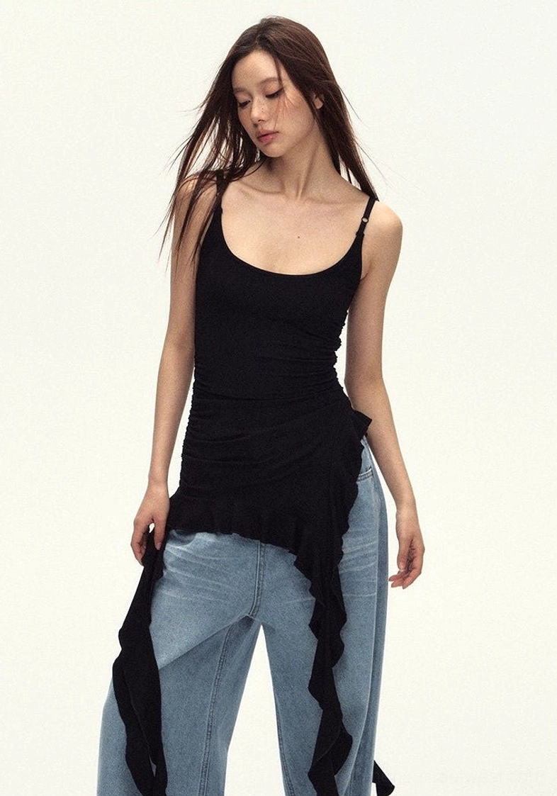 Side profile of a slim black cami top with a dramatic asymmetric ruffled hem and flowing streetwear silhouette