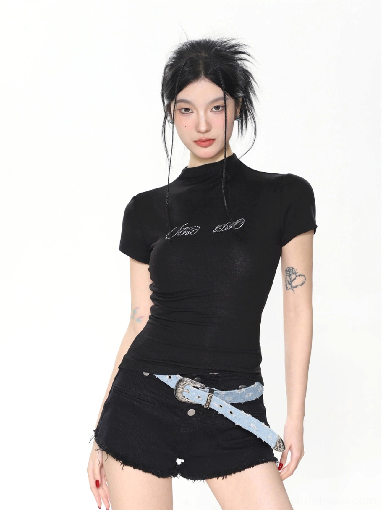 Black women’s slim fit mock neck baby tee with subtle embroidered chest detail styled with denim shorts