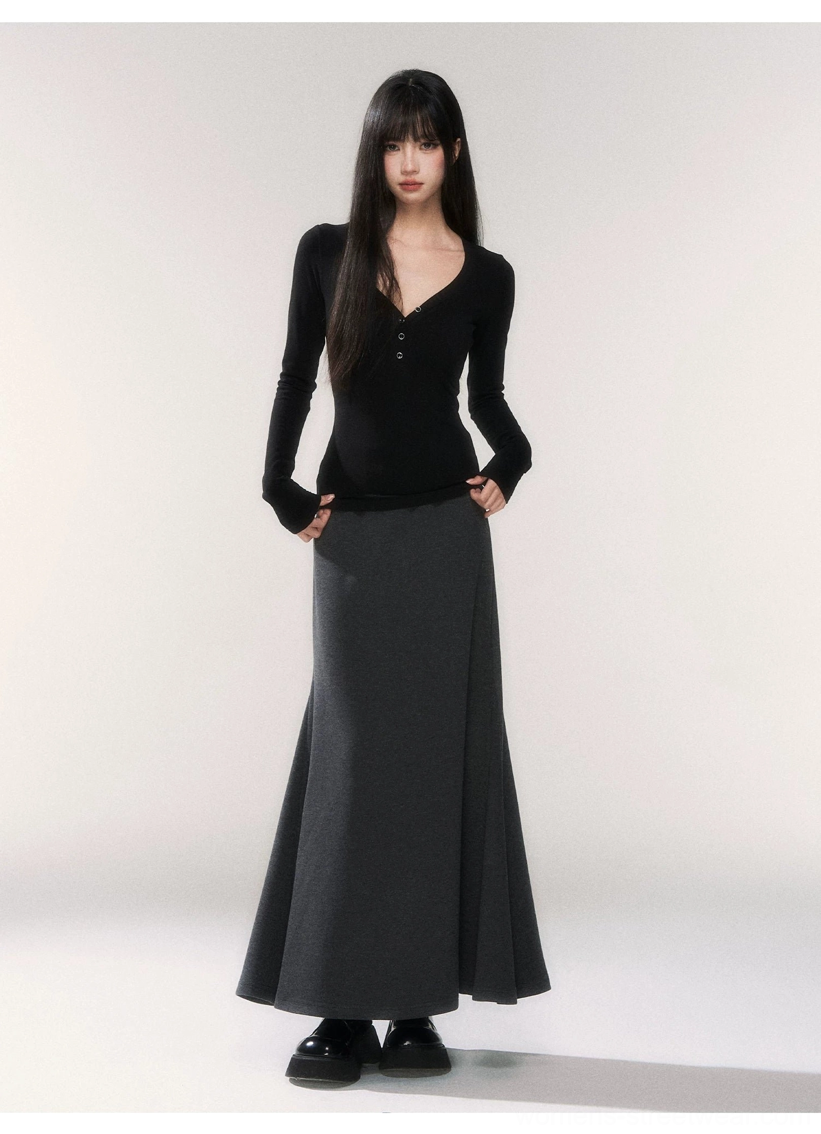 Black slim fit V-neck button placket knit top styled with a floor-length gray skirt in contemporary Korean fashion