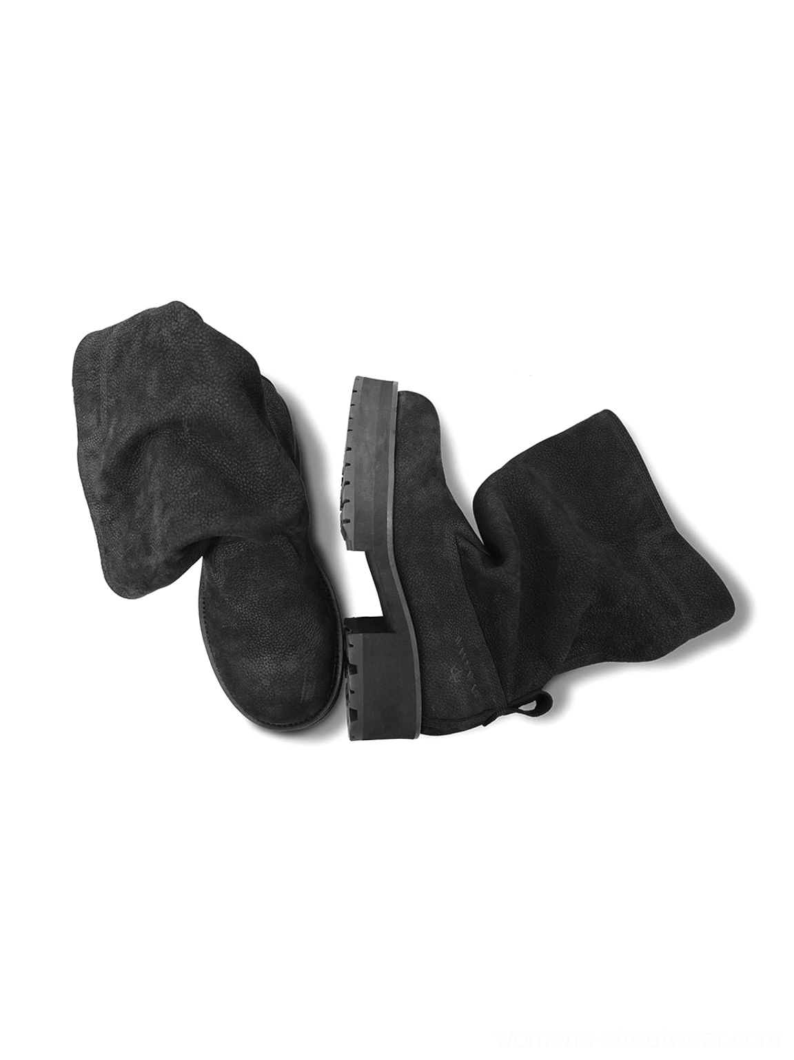 Oblique side display of black slouch mid-calf boots showing the loose folded cuff, textured leather upper, and rugged streetwear outsole