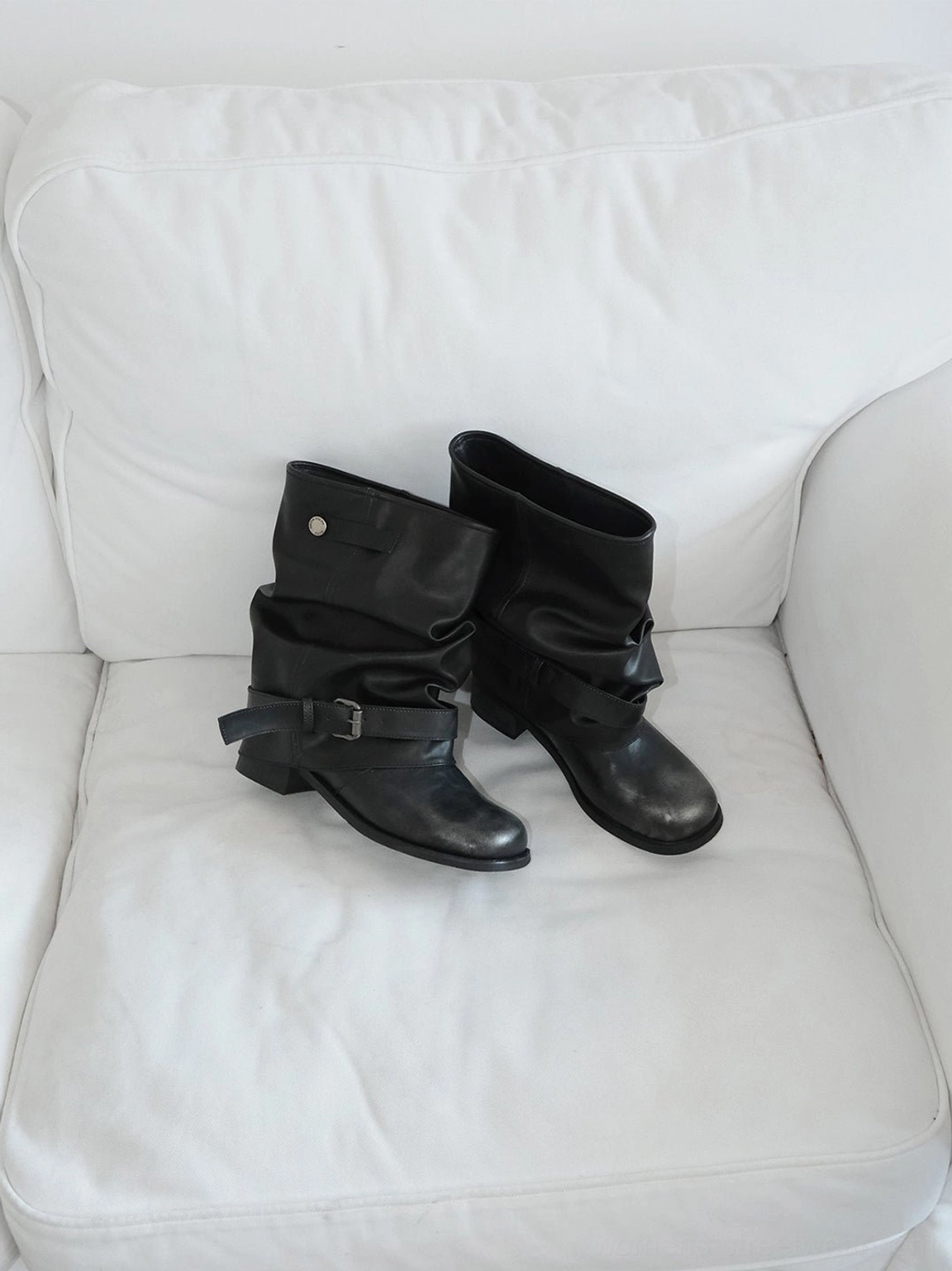 Black slouchy mid-calf boots with rounded toe, ruched shaft, and grounded block heel