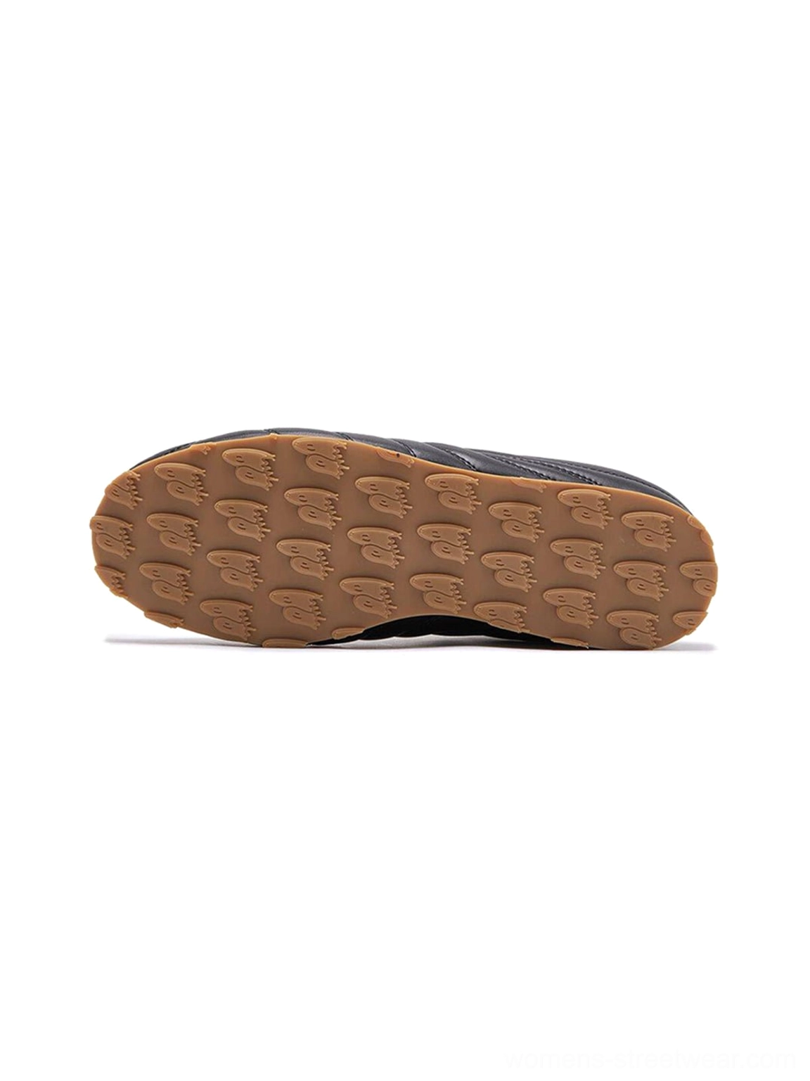 Black soccer trainer sneakers with tonal quilted texture, low-cut profile, and warm brown gum rubber sole