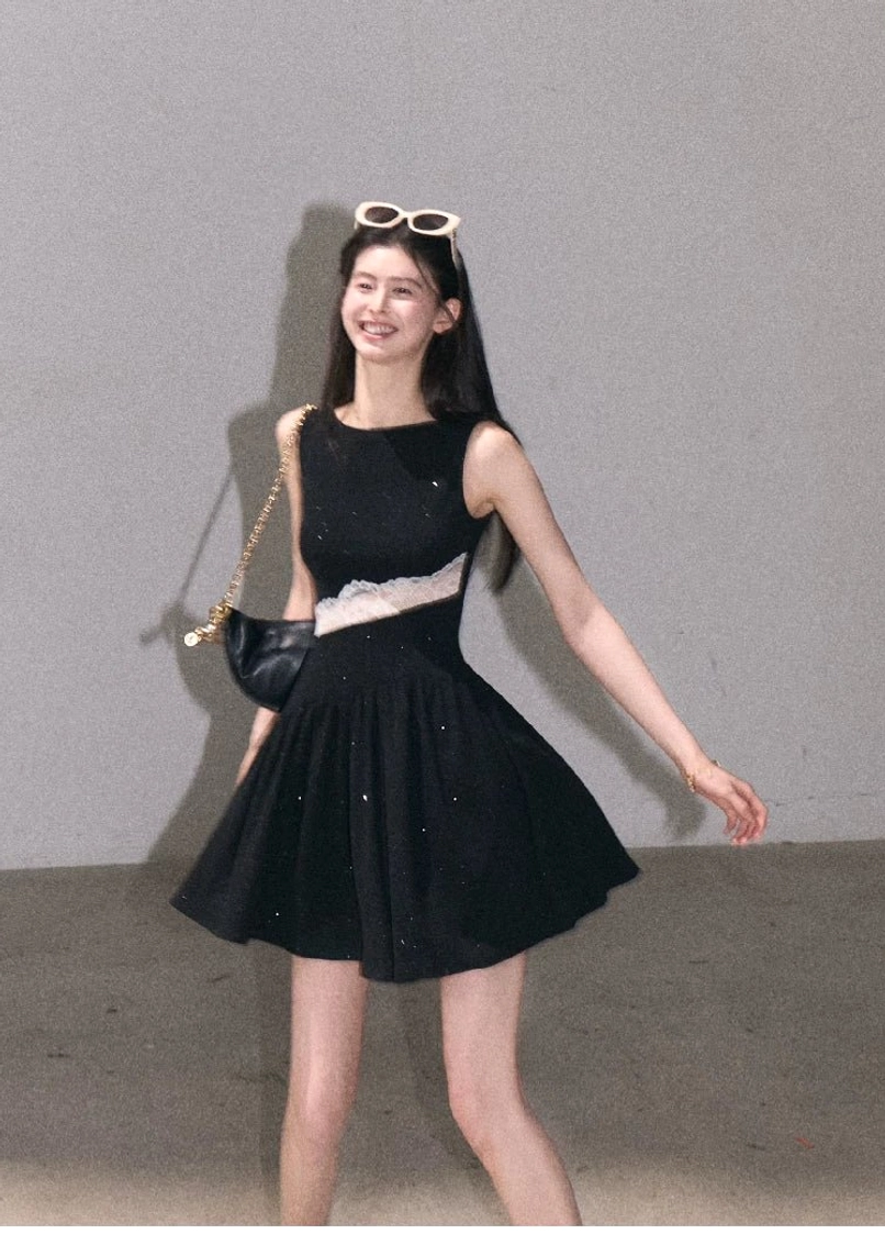 Black sparkly asymmetrical lace waist mini dress with white lace detail styled with a chain shoulder bag