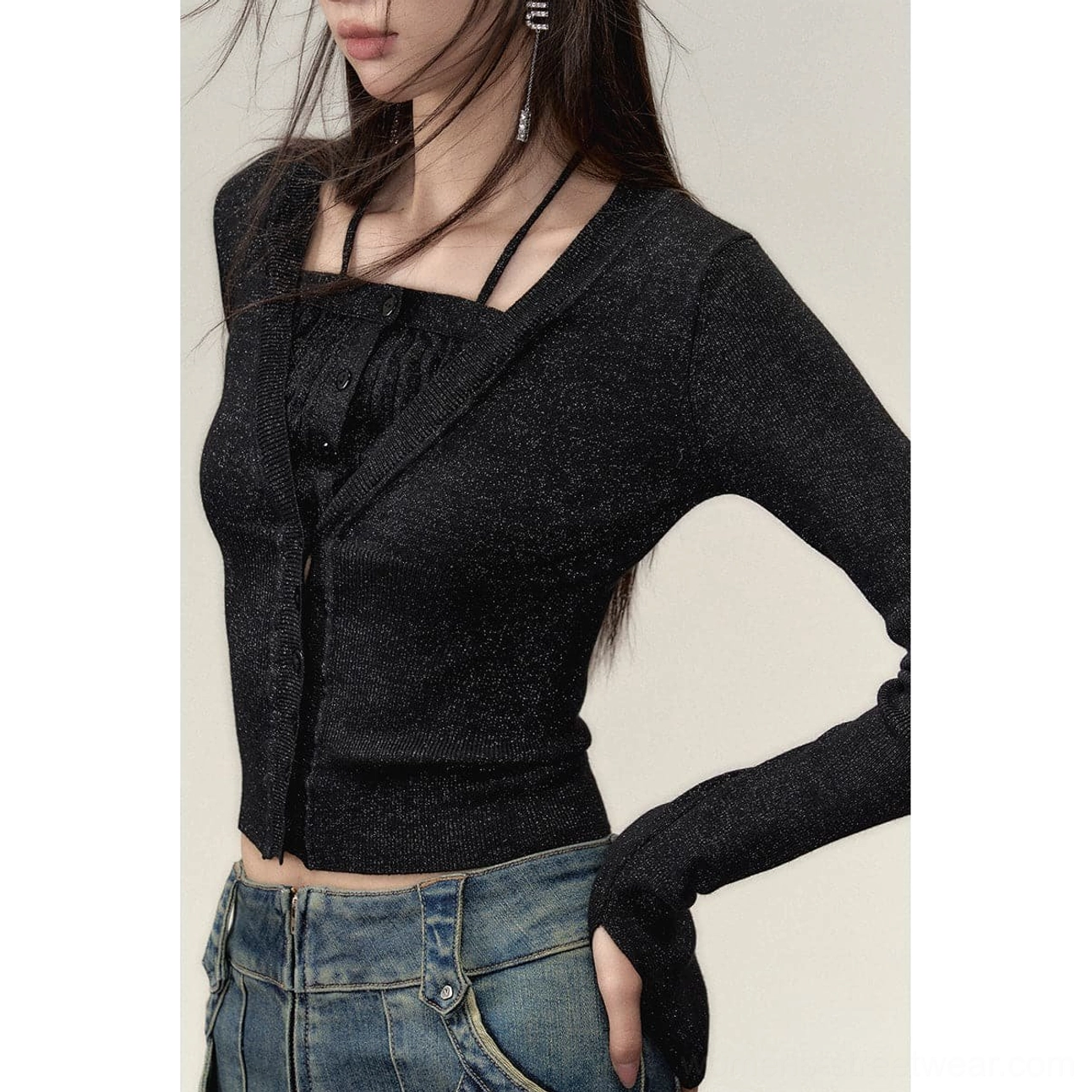 Close-up side view of a black sparkly cropped knit top with square neckline, halter strap, ruched front, button placket and slim sleeves